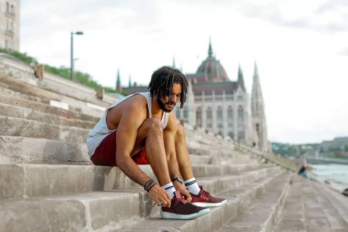 Homme portant des baskets de luxe élégantes sur un trottoir urbain