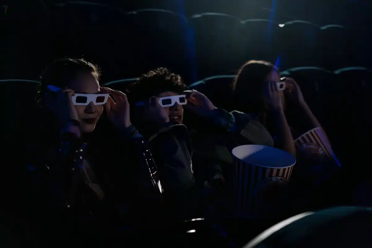 Adolescent dans une salle de cinéma des années 1980, observant l'écran dans l'obscurité
