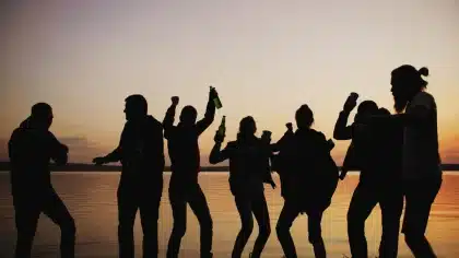 Silhouette de danseur célébrant au coucher du soleil avec une atmosphère chaleureuse et festive