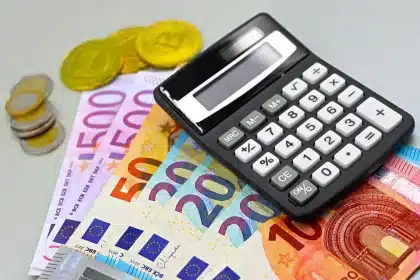 Pièces de monnaie, billets et documents financiers sur un bureau avec une calculatrice