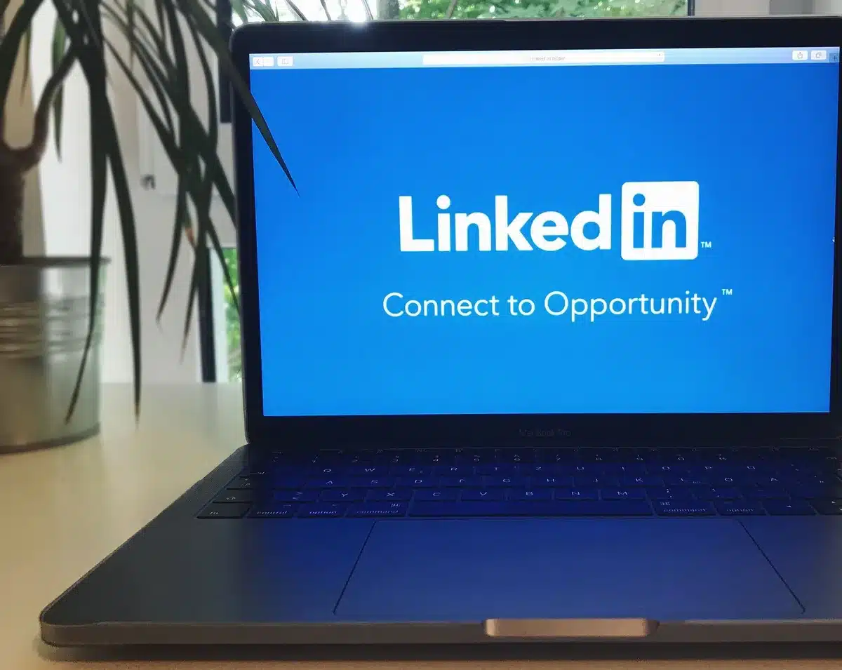 Profil LinkedIn affich&eacute; sur un &eacute;cran avec interface de messagerie personnalis&eacute;e.