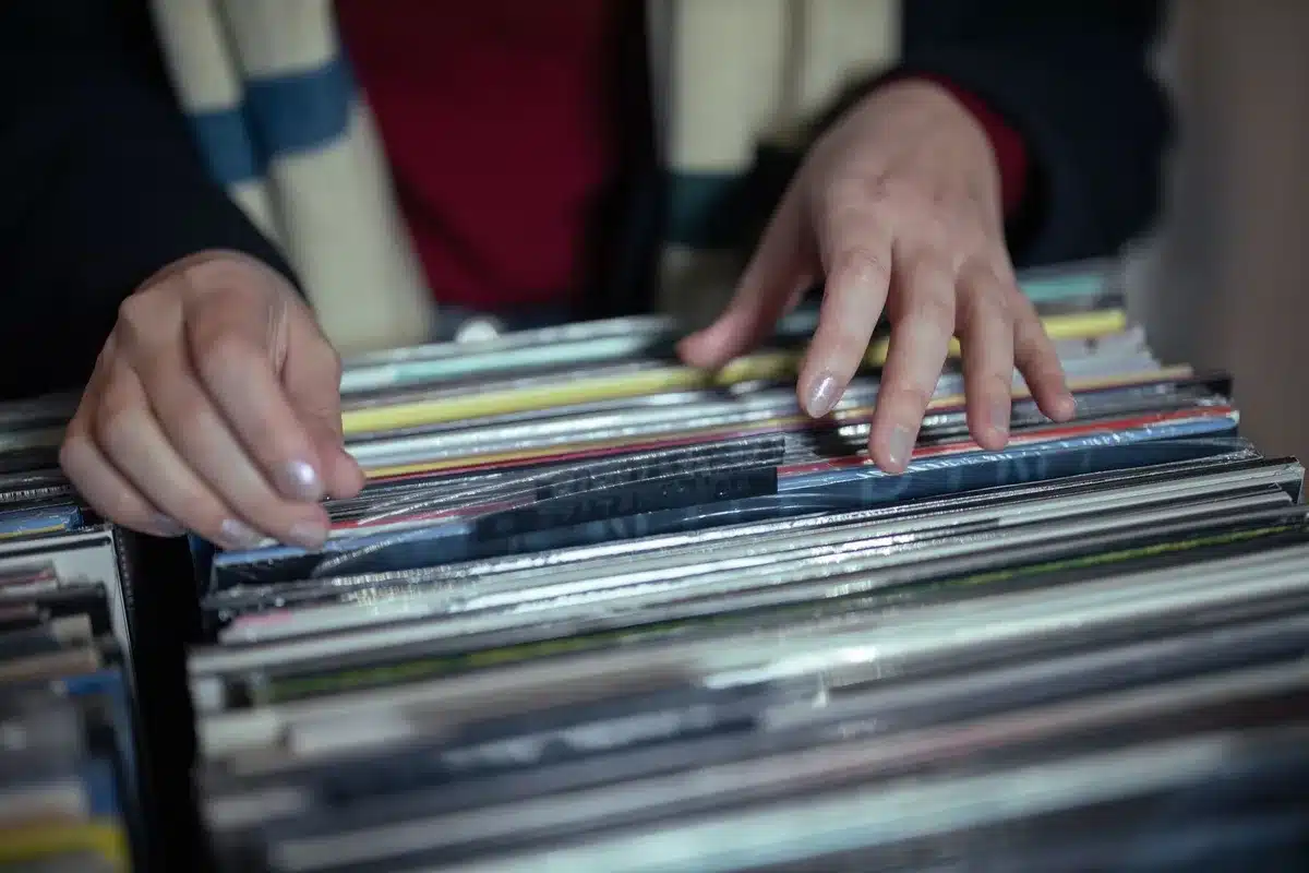 Mains ouvrant une pochette de vinyle avec des détails créatifs et insolites, présentant le disque à l'intérieur