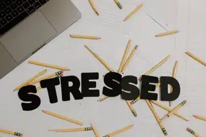 Personne assise à un bureau le dimanche soir, consulte son agenda et regarde par la fenêtre