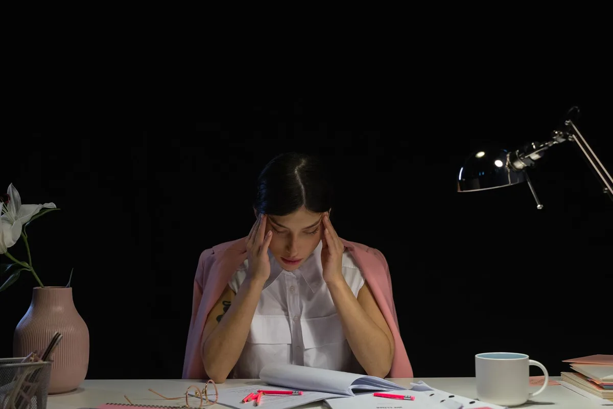 Employé isolé travaillant seul à son bureau, montrant les signes de stress et de solitude au travail