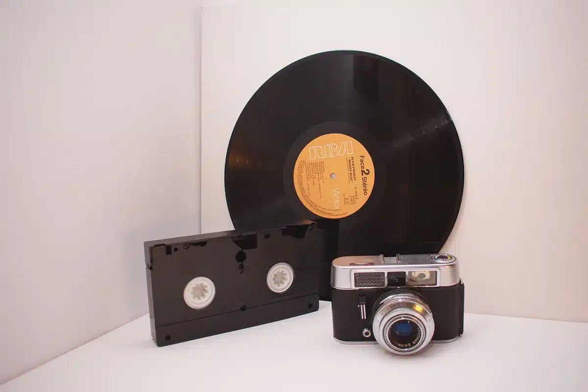Objets analogiques vintage incluant caméra, disques vinyle et appareils photo anciens