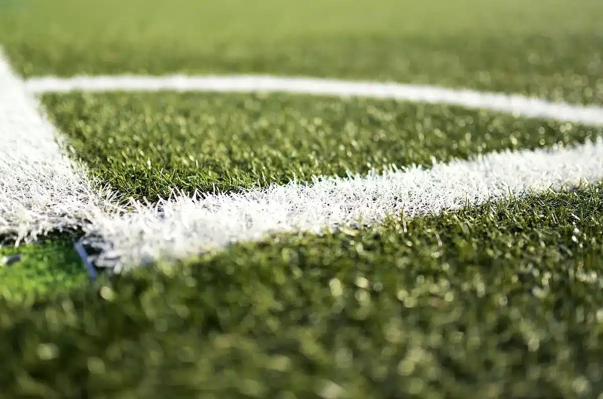 Un joueur de football quittant l'entraînement, poussette à proximité symbolisant la vie de famille
