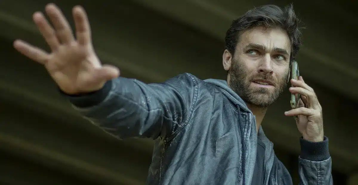 Deux silhouettes discutant sur un plateau de tournage, caméra en arrière-plan