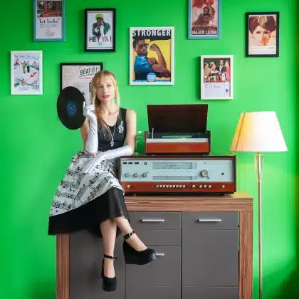 Main tenant un vinyle près d'une tablette dans un studio sombre, symbolisant musique et IA