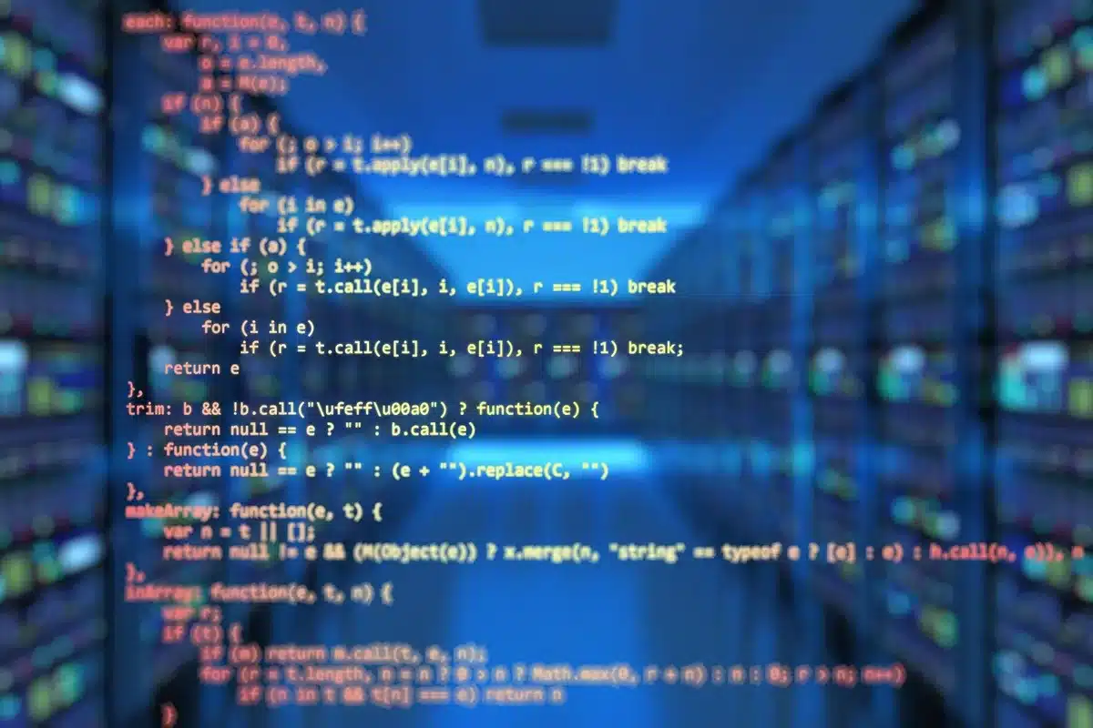 Équipe d'ingénieurs devant des écrans en train de coder et discuter l'architecture logicielle