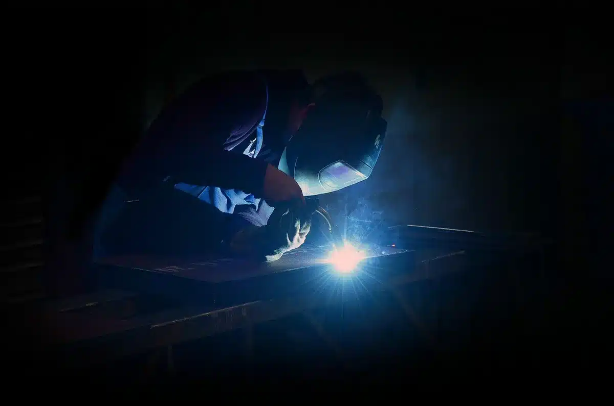 Mains d'un technicien assemblant des composants robotiques sur un établi d'atelier industriel