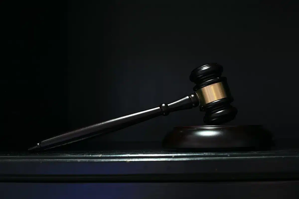 Un maillet et des dossiers juridiques sur une table de tribunal