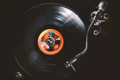 Mains anonymes tenant un vinyle près d'une platine dans un petit club
