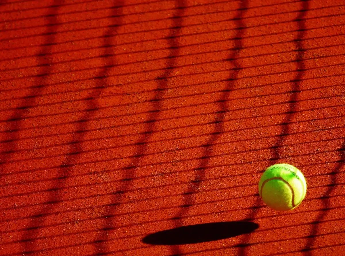 Jeune joueur de tennis concentré sur un court en terre battue
