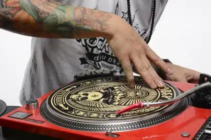 Plateau de DJ avec platines, console et pochettes de vinyles sur une table en bois