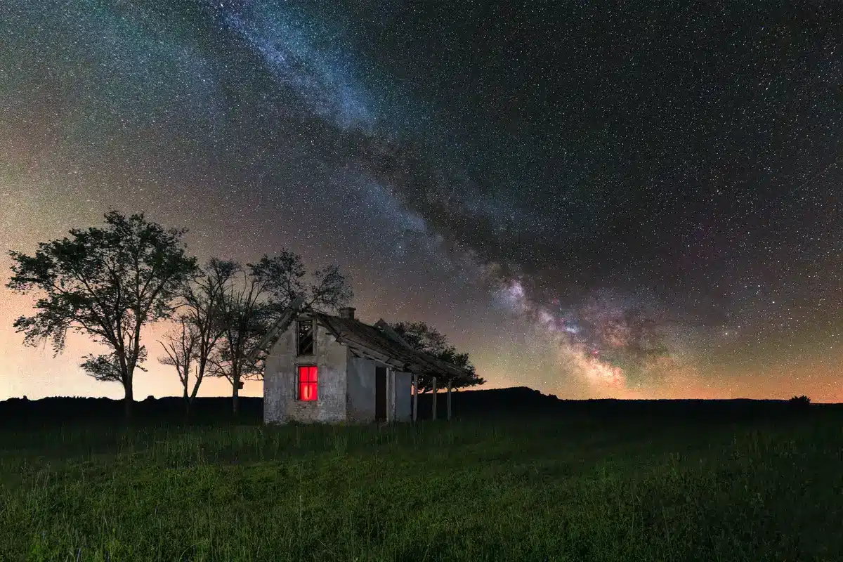 Fermier anonyme observant le ciel étoilé depuis un champ rétro‑futuriste