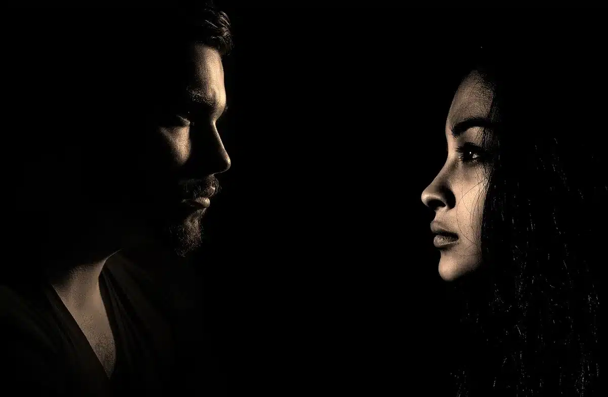 Silhouettes de deux musiciens dans un studio avec synthétiseurs, ambiance créative