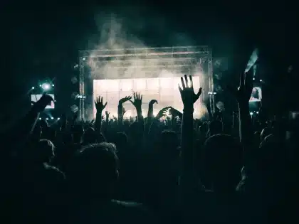 Vue d'une piste de club sombre avec platines et silhouettes en arrière-plan