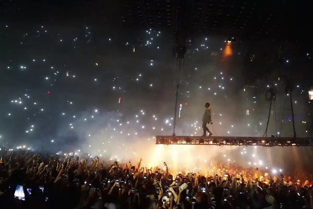 Scène extérieure avec DJ et public lors d'un concert électronique