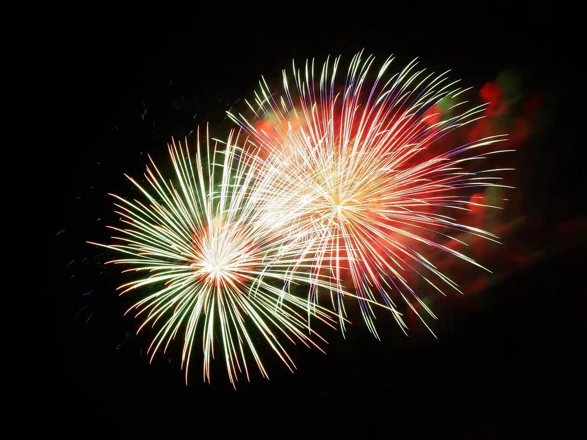 Spectacle pyrotechnique nocturne avec étincelles et danseurs silhouettes