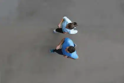 Coureurs anonymes en tenue sportswear marchant sur un trottoir urbain au petit matin