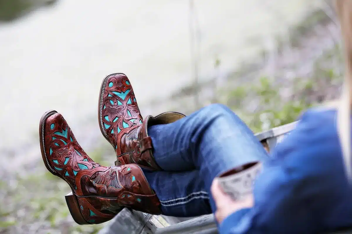 Jean customisé avec broderies et breloques, gros plan sur les jambes